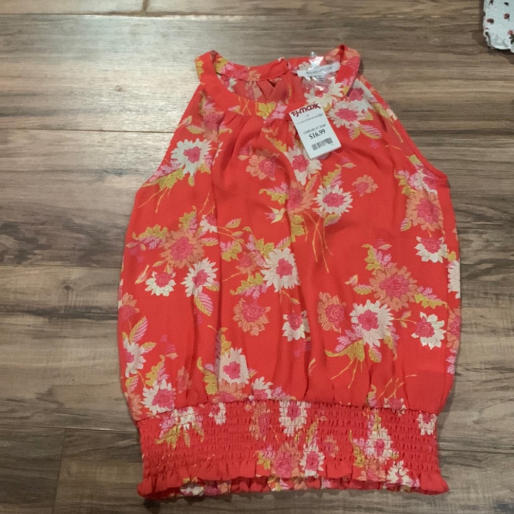An orange shirt that has never been worn and still has tags from TJ Max